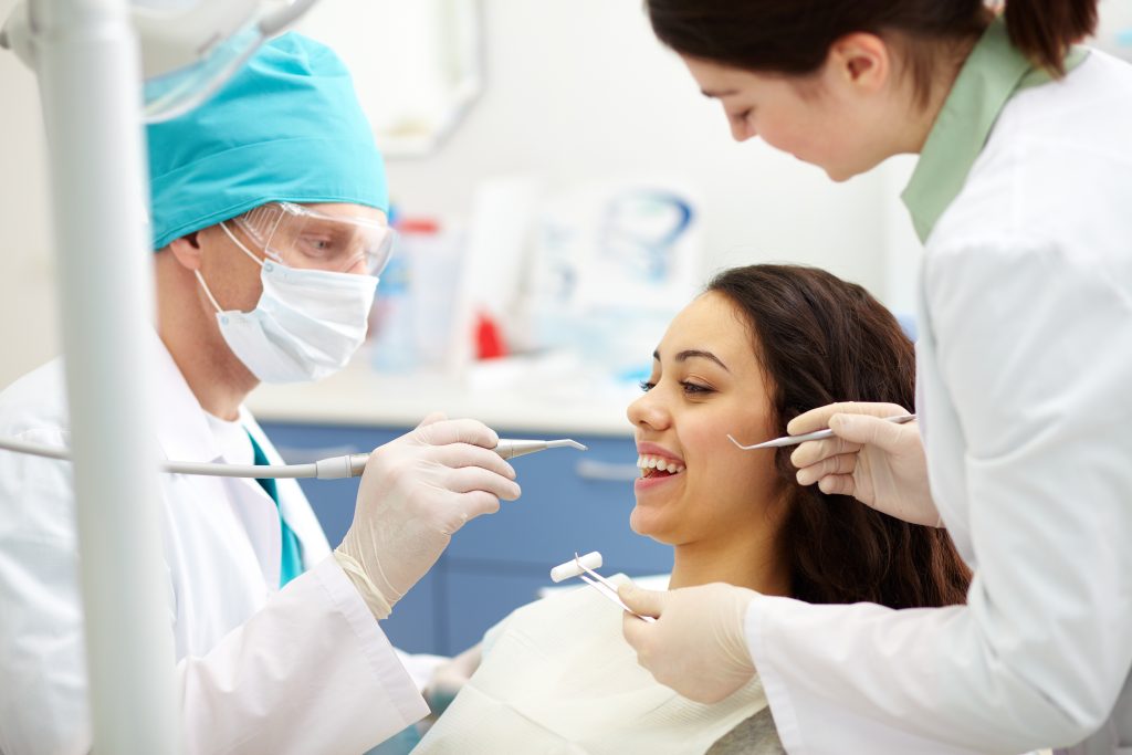 Signature Smiles Dental Group Dentists examining patients teeth for Veneers